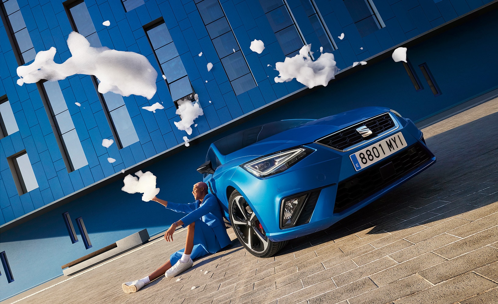 Man met belleblaas naast blauwe SEAT Ibiza